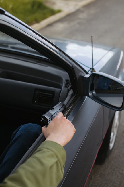 a man holding a gun in a vehicle